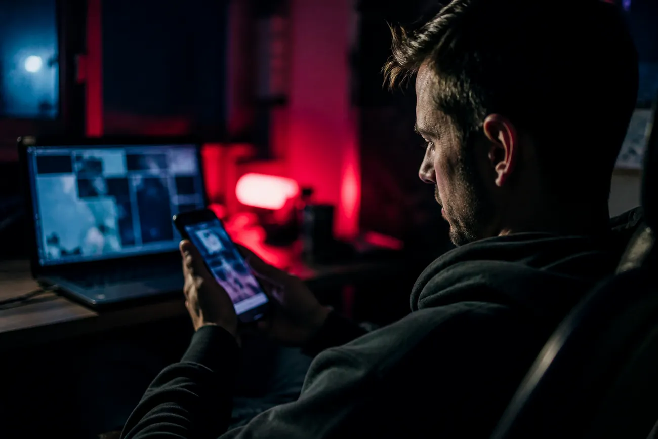 person navigating dark web video sites on smartphone